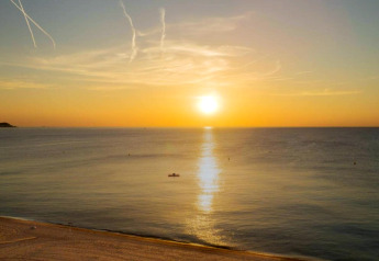 Coucher de soleil sur la mer depuis Camping Interpals- Bungalow Sa Riera en Espagne, plage paisible et mer calme.