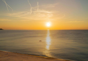 Zonsondergang over de zee bij Camping Interpals- Bungalow Sa Riera in Spanje, serene strand en kalm water.
