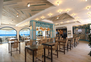 Heldere, moderne eetzaal van Tamarit Park Resort 1 THALASSA in Spanje met zeezicht en stijlvolle inrichting.
