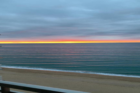 Solnedgangsudsigt over havet og stranden fra CAMPING INTERPALS-Bungalow Sa Riera, Spanien, med farverige skyer.