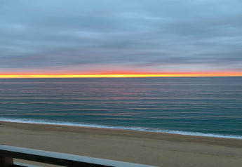 Zonsondergang over zee en strand gezien vanaf CAMPING INTERPALS-Bungalow Sa Riera in Spanje, kleurrijke lucht.