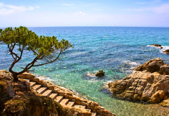 Escalier en pierre menant à la Méditerranée claire au Camping Interpals-Bungalow Sa Riera en Espagne.