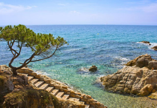 Stenstrin fører ned til det klare Middelhavsvand ved Camping Interpals-Bungalow Sa Riera i Spanien.