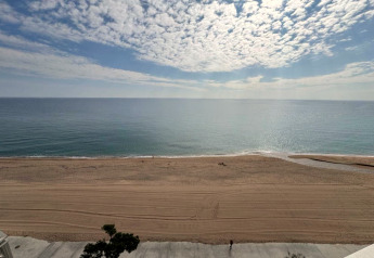 Vue sur la plage depuis Camping Interpals- Bungalow Sa Riera, Espagne, avec sable, mer et ciel nuageux.