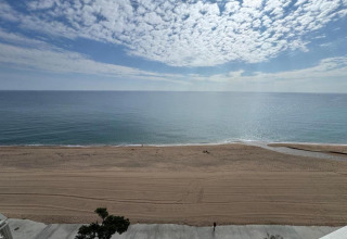 Strandudsigt ved Camping Interpals- Bungalow Sa Riera, Spanien med himmel, hav og sandstrand.