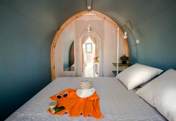 Intérieur d'une tente safari avec lit double, chapeau d'été et accessoires au Camping Estival Torre de la Mora, Espagne.