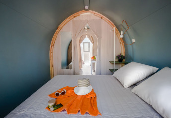 Innenansicht eines Safari-Zeltes mit Doppelbett, Sommerhut und Utensilien auf einem Campingplatz in Spanien.