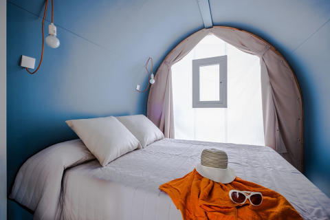 Interiør af COCO TENT 4 Pax på Camping Estival Torre de la Mora, Spanien, med dobbeltseng og blå vægge.