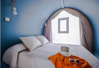 Interiør af COCO TENT 4 Pax på Camping Estival Torre de la Mora, Spanien, med dobbeltseng og blå vægge.
