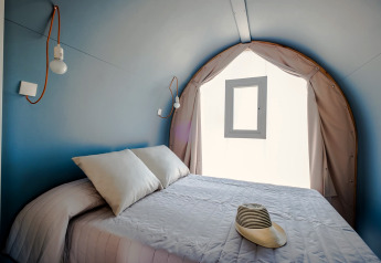 Chambre intérieure d'une COCO TENT au Camping Estival Torre de la Mora, Espagne, avec lit et fenêtre.