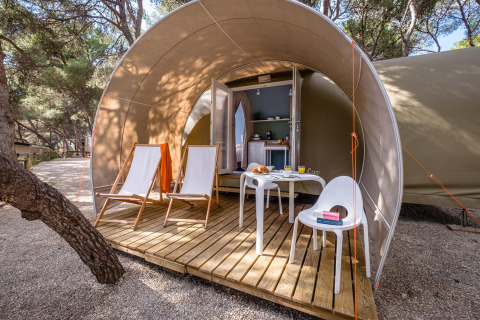 Safari-telt Camping Estival Torre de la Mora COCO TENT 4 Pax i Spanien med træterrasse, stole og bord.