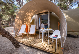 Safari-telt Camping Estival Torre de la Mora COCO TENT 4 Pax i Spanien med træterrasse, stole og bord.
