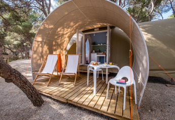 Safari-Zelt Camping Estival Torre de la Mora COCO TENT 4 Pax in Spanien mit Holzterrasse, Stühlen und Tisch.