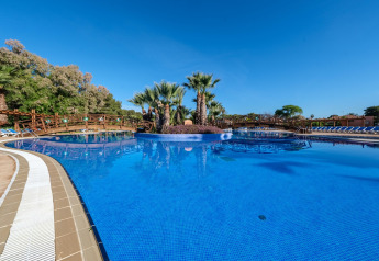 Großer Pool mit Palmen und Holzbrücken bei Camping Estival Torre de la Mora COCO TENT 4 Pax in Spanien.
