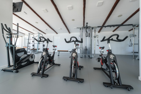 Moderne fitness in een glamping accommodatie met spinningfietsen en krachttoestellen.