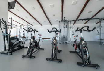 Modernes Fitnessstudio in einer Glamping-Unterkunft mit Spinningrädern und Kraftgeräten.