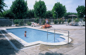 Piscina al aire libre en Camping Cambrils Playa 2 BUNGALOW PREMIUM en España con niños y personas relajadas.