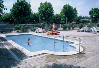 Piscina al aire libre en Camping Cambrils Playa 2 BUNGALOW PREMIUM en España con niños y personas relajadas.