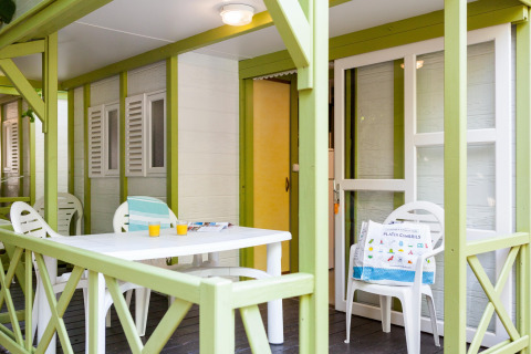Overdekt terras bij Camping Cambrils Playa 2 BUNGALOW PREMIUM in Spanje met tafel, stoelen en drankjes.
