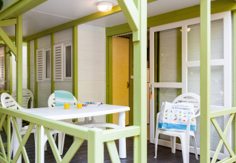 Terraza exterior en Camping Cambrils Playa 2 BUNGALOW PREMIUM en España con mesa, sillas y bebidas.