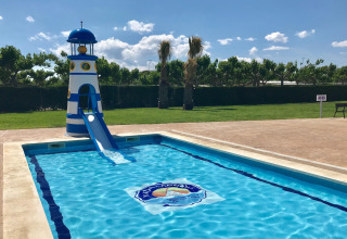 Piscina infantil con tobogán de faro en Camping Cambrils Playa 1 BUNGALOW OASIS, España.