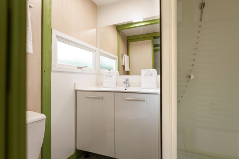 Baño moderno en Camping Cambrils Playa 1 BUNGALOW OASIS, España, con ducha, espejo grande y luz natural.