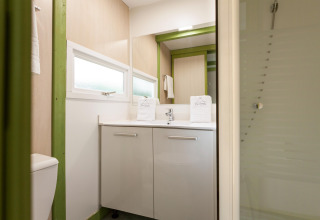 Baño moderno en Camping Cambrils Playa 1 BUNGALOW OASIS, España, con ducha, espejo grande y luz natural.