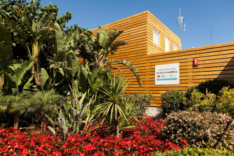 Foto de un alojamiento glamping en Platja Cambrils rodeado de plantas tropicales y coloridas flores.