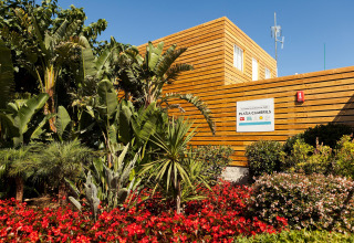 Foto de un alojamiento glamping en Platja Cambrils rodeado de plantas tropicales y coloridas flores.