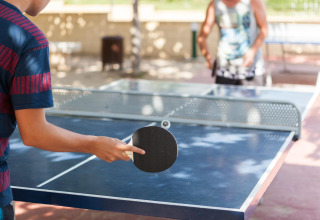 Dos personas juegan al tenis de mesa al aire libre en Camping Cambrils Playa 1 BUNGALOW OASIS, España.
