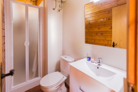 Salle de bain moderne à La Llosa Ponent en Espagne avec douche, toilettes, lavabo et murs en bois.