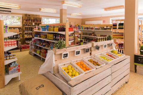 Épicerie lumineuse avec fruits frais et produits courants dans un hébergement glamping, ambiance moderne.