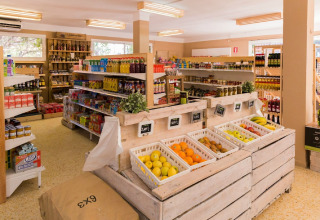Épicerie lumineuse avec fruits frais et produits courants dans un hébergement glamping, ambiance moderne.
