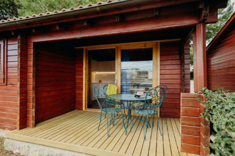 Baita in legno con veranda e sedie verdi, foto scattata a La Llosa 3 LLEBEIG in Spagna.