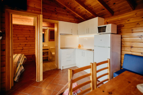 Accogliente baita La Llosa 3 LLEBEIG in Spagna con interni in legno, cucina, zona pranzo e bagno visibile.