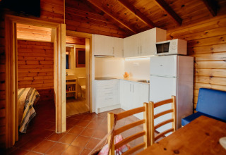 Accogliente baita La Llosa 3 LLEBEIG in Spagna con interni in legno, cucina, zona pranzo e bagno visibile.