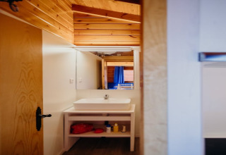 Vista di un bagno con soffitto in legno e specchio nella cabina La Llosa 3 LLEBEIG in Spagna.