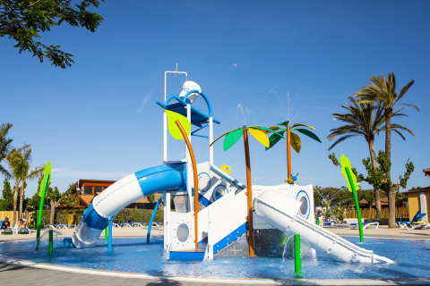 Parco giochi acquatico con scivoli e palme presso La Llosa 3 LLEBEIG, Spagna, in una giornata soleggiata.