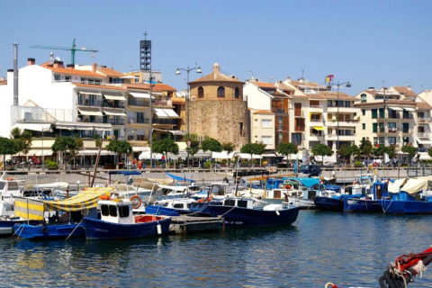 Vue sur le port de plaisance avec des bateaux colorés et des immeubles depuis un hébergement glamping.