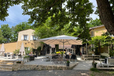 Gemütlicher Außenbereich mit Sonnenschirmen und Sitzgelegenheiten im Camping Le Clou 1 in Frankreich.