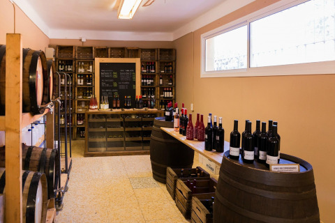 Sala dei vini a La Llosa Mestral Bungalows in Spagna con botti, bottiglie e scaffali di vino assortiti.