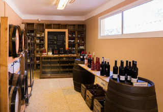 Sala dei vini a La Llosa Mestral Bungalows in Spagna con botti, bottiglie e scaffali di vino assortiti.