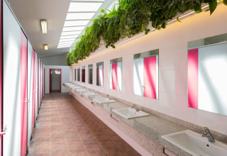 Bagno moderno a La Llosa Mestral-BUNGALOWS-G in Spagna con specchi, lavandini e piante sospese.