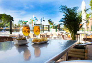 Due birre e snack su un tavolo sulla terrazza soleggiata di La Llosa Mestral-BUNGALOWS-G in Spagna.