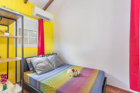 Dormitorio colorido en Bungalow «avec piscine au cœur de la campagne Vert» en Portugal con cama doble.