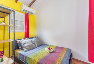 Dormitorio colorido en Bungalow «avec piscine au cœur de la campagne Vert» en Portugal con cama doble.
