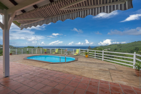 Terraza con piscina, vistas al mar y colinas en Bungalow 'avec piscine au cœur de la campagne Vert' en Portugal.