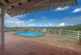 Terraza con piscina, vistas al mar y colinas en Bungalow 'avec piscine au cœur de la campagne Vert' en Portugal.