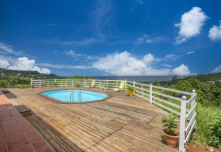 Terraza soleada con piscina y vistas al campo en el Bungalow «avec piscine au cœur de la campagne Vert» en Portugal.