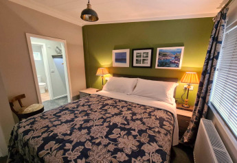 Chambre confortable au New Puddledock Lodge, Royaume-Uni, avec lit double et mur d’accent vert.
